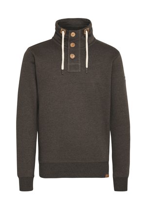 Tummanruskea neulepaita korkealla kauluksella, kolmella napilla ja vaalean beigeillä nyöreillä, jossa on tekstuuri ja rimmitetyt hihansuut.