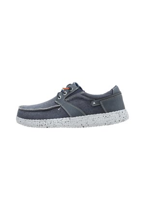 Zapato casual azul marino con cordones, suela blanca moteada, parte superior de tela y cuero, y detalle de cordones en naranja a contraste en el lateral.
