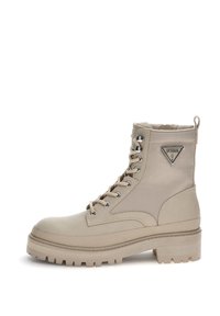Beżowe botki typu high-top z mixem gładkich i teksturowanych materiałów, sznurowanym zapięciem oraz detalem z logo po zewnętrznej stronie. Ząbkowana podeszwa.