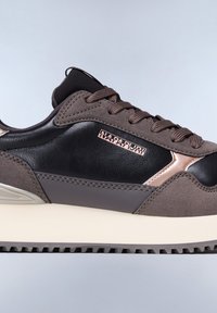 Sneakers con una combinazione di suede marrone scuro e pelle nera, con suola crema e un'icona metallica sul lato.