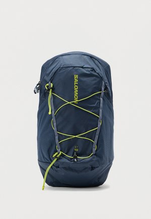 De Salomon-rugzak heeft een donkerblauwe, gestructureerde stof met neongele accenten, een ontwerp met elastisch koord en een afgeronde vorm voor functionaliteit.