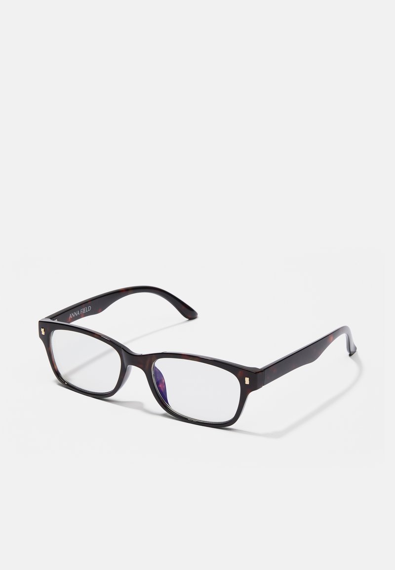 Ορθογώνια γυαλιά με σκούρο καβουρδιστό σκελετό, διάφανοι φακοί και χρυσές τετράγωνες λεπτομέρειες στους βραχίονες.