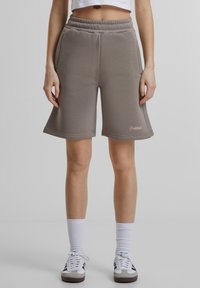 Grå bomullsblandingsshorts med elastisk linning, med avslappet passform og sidelommer, aksentert med en liten logo nederst.