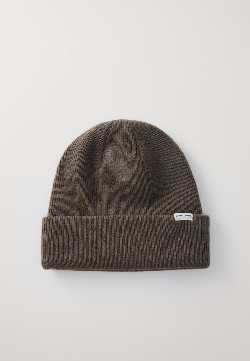 Brun strikket beanie-hat med omslået kant, der har fine ribmønstre og en lille hvid mærkeetiket syet på siden.