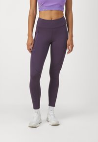 Leggings morados de cintura alta hechos de material elástico, con costuras suaves y bolsillos laterales para mayor comodidad.