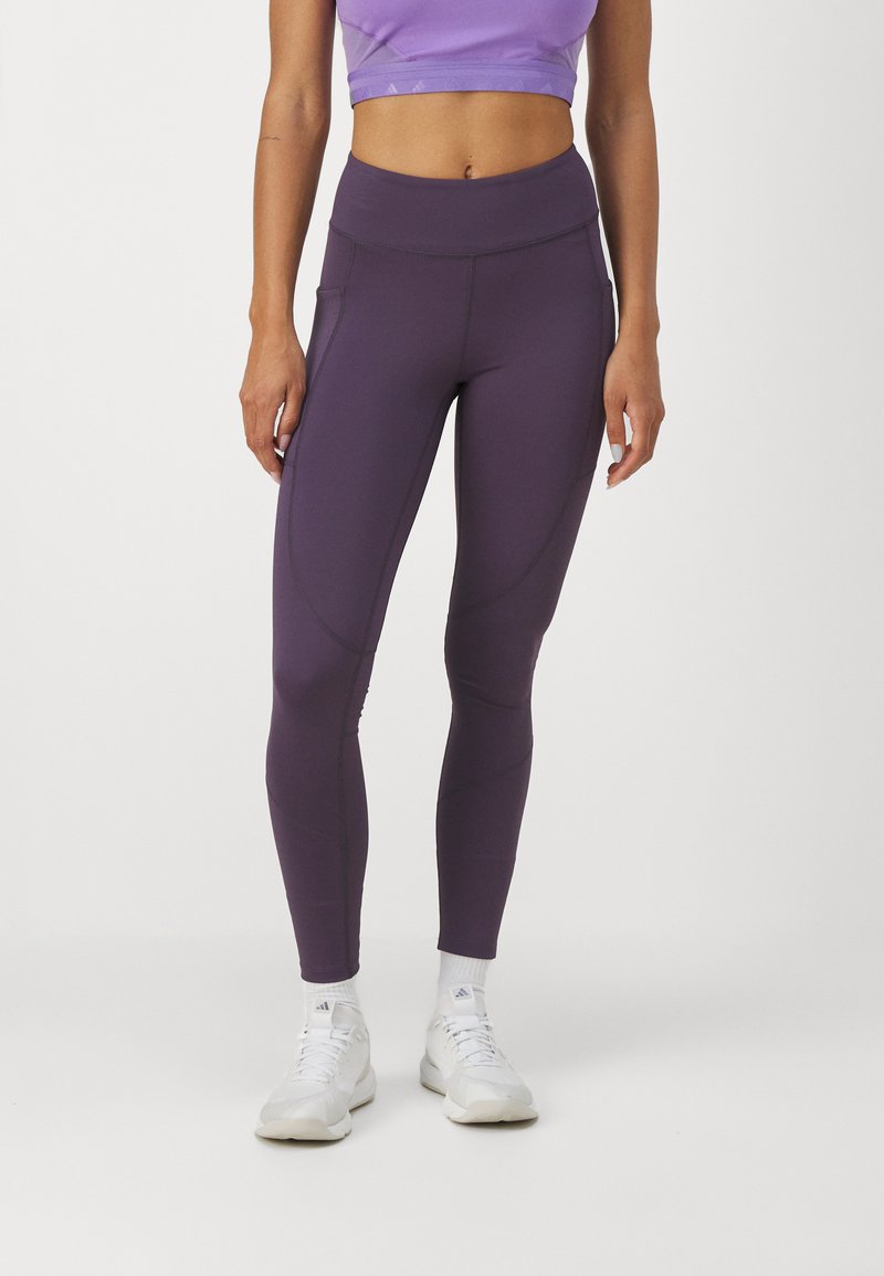 Leggings morados de cintura alta hechos de material elástico, con costuras suaves y bolsillos laterales para mayor comodidad.