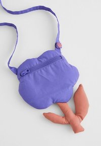 Violeta auduma soma, kas veidota kā mākonis, ar rāvējslēdzēja nodalījumu. Tai ir korallkrāsas, mīksts kāts un gara, regulējama siksna.