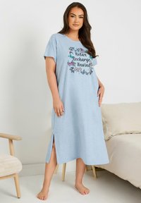 Ljusblå nattlinne av mjukt tyg, med korta ärmar, sidoflikar och en blommig grafisk design med texten "Slappna av, ladda om och koppla av".