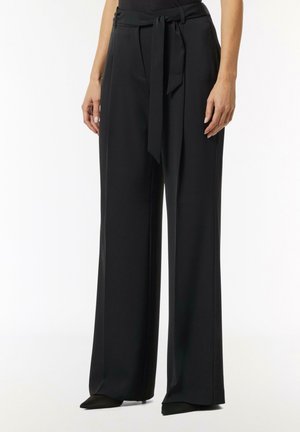 Black wide-legged pants with a high waist, made from smooth fabric. Features a tied belt, front pockets, and a relaxed silhouette.