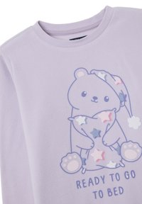 Purple fleece top featuring a bear graphic holding a pillow with colorful stars. Text "READY TO GO TO BED" printed below the design.