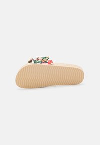 Sandal s květinovým vzorem na krémovém podkladu, s texturovanou gumovou podrážkou a vyvýšenou, vycpanou částí nahoře. Hladká mašle jako akcent na vrcholu.