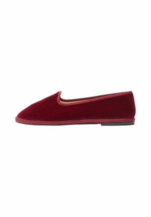 Mocasín de terciopelo burdeos plano con puntera redonda, ribete cosido y suela negra, mostrado en perfil lateral sobre un fondo blanco.