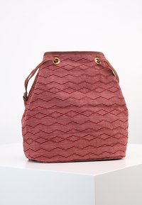 Rød og beige tekstureret stof bucket-taske med geometriske mønstre, læderrem og messingdetaljer. Åben top med justerbar snøring.