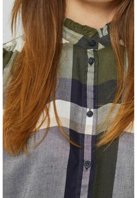 Chemise à carreaux verte et marine à boutons, avec un col mandarin, des boutons contrastants et un tissu texturé au fini doux.