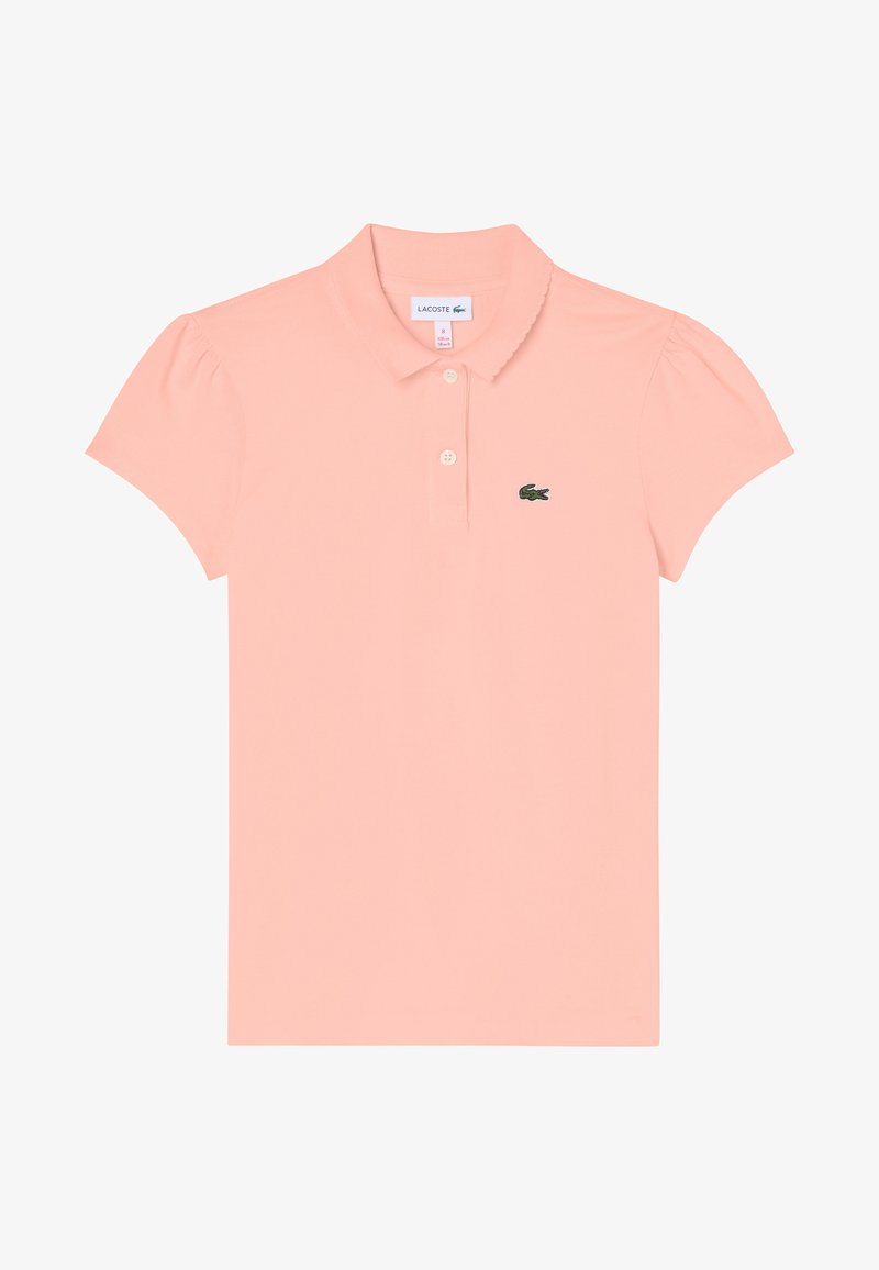 Polo en tissu pêche doux avec un col ajusté, des manches courtes bouffantes, une patte de boutonnage à trois boutons et un logo brodé vert sur la poitrine.