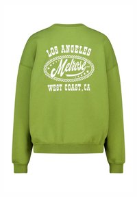 Groene sweatshirt met witte tekst: "LOS ANGELES Melrose ave WEST COAST, CA" omringd door decoratieve sterren en een ovale rand.