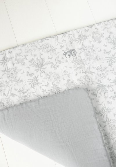 Πλεκτή κουβέρτα με λευκό ύφασμα που φέρει γκρι λουλουδένια σχέδια και πεταλούδες, σε συνδυασμό με γκρι μονόχρωμη πίσω πλευρά και κεντητό διακοσμητικό.