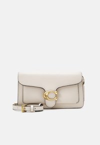 Bolso cruzado de cuero crema con un cierre de color dorado, forma estructurada, costuras en contraste de color negro y una correa ajustable.