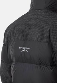 Black puffer jacket featuring a checkered pattern on the top half, smooth lower section, and a logo printed on the back.