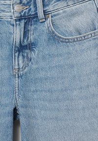 Jean en denim bleu clair avec poche avant, rivets en métal, passants de ceinture et fermeture par bouton.