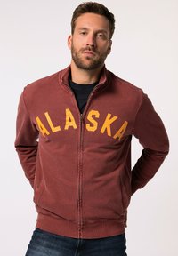 Felpa con zip color bordeaux che presenta "ALASKA" in bold lettere gialle sul petto, con collo, tasche e polsini e orlo a coste.