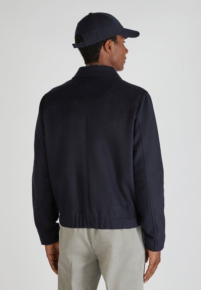 Marineblaue Wollmischjacke mit geradem Schnitt, gerippten Manschetten und hohem Kragen. Verfügt über eine glatte Textur und ein minimalistisches Design.