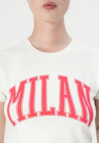 Hvit bomulls t-skjorte med dristig rød "MILAN" tekst i en buet design. Rund hals og korte ermer med en jevn tekstur.