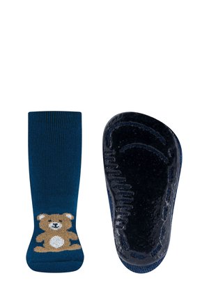 Navy blue socks with a brown bear design on the ankle. The sole features a textured, non-slip surface. Soft knit fabric.
