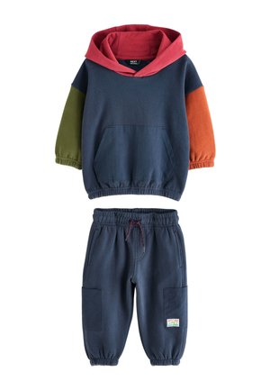 Barnett sæt i to dele med marineblå hættetrøje med rød hætte, grønne og orange ærmer samt matchende marineblå joggebukser med lappelommer.