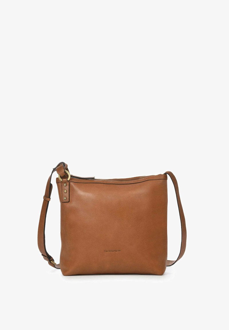 Bolso de hombro de cuero en tono marrón claro con cierre de cremallera, correa ajustable y diseño minimalista. Presenta un sutil logo en relieve en la parte frontal.