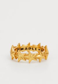 Kuldne sõrmus, millel on ümber bändi pidev rida tõstetud viiepunktiga tähti ja seesama graveeritud tekst.