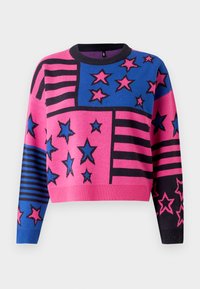 Rosa og blå cropped genser med stjerne- og stripe mønster, med svart ribbestrikket halskant og mansjetter. Strikket tekstur med levende farger.