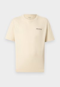 Μπεζ μπλουζάκι με κοντά μανίκια, με μικρό λογότυπο της ομάδας McLaren Formula 1 στο αριστερό στήθος και στρογγυλή λαιμόκοψη.