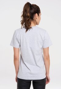 Gray cotton t-shirt with short sleeves, crew neck, and a smooth texture. The back view shows a relaxed fit and no visible logos or patterns.
