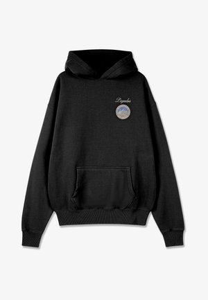 Mustaa hupparia, jossa on etutasku ja pyöreä merkki rinnassa, jossa on vuoristokuvasto ja teksti. Pehmeä kangas, rento muotoilu.