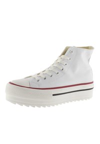 Sneaker alta bianca con tomaia in tela, punta in gomma e suola spessa e testurizzata bianca. Presenta strisce orizzontali rosse e nere.