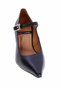 Scarpa Mary Jane nera a punta con cinturino a fibbia argentata e interno color ambra, visibile su sfondo bianco.