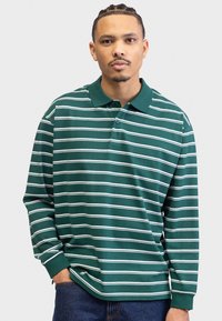 Green long-sleeve polo shirt with white horizontal stripes, featuring a collar and button placket, made from a soft, lightweight fabric.