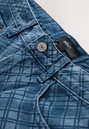 Modré džíny z denimu s prošívaným vzorem, na pase mají kulatý kovový knoflík a černou etiketu s nápisem "NEXT".