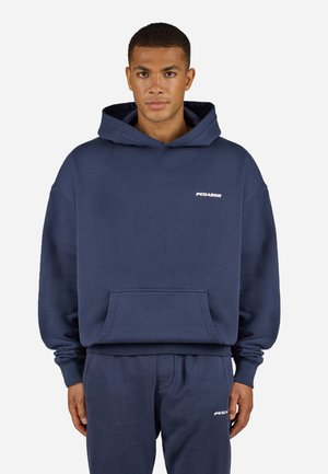 Navy blue fleece hoodie with a kangaroo pocket, ribbed cuffs, and a white logo on the chest; paired with matching pants.