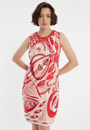 Robe sans manches à motifs rouges, dotée d'un col froncé avec des accents. Le design comprend des tourbillon et des motifs floraux dans différentes nuances de rouge.