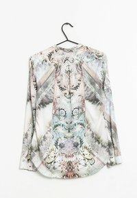 Blusa a maniche lunghe con un motivo astratto multicolore, caratterizzata da tonalità di rosa, blu e nero su un tessuto leggero.