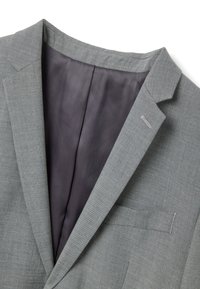 Grijze stoffen blazer met een notched revers, een gestructureerde buitenkant en een gladde, donkere voering aan de binnenkant. Voorzien van een enkele borstzak.