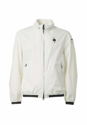 Giacca bianca leggera con collo alto, cerniera frontale, tasche laterali con zip, polsini elastici e piccole toppine nere con logo su petto e manica.