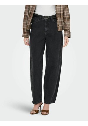 Person iført sorte jeans med højtaljet pas med sort bælte, brune åbne hæle med åben tå, hvid top og brun ternet skjorte.