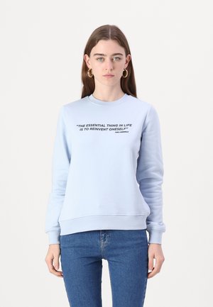Light blue sweatshirt in soft cotton fabric with a round neckline and long sleeves. Features bold black text on the front. Fitted style.