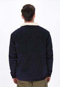 Marineblaue Cordjacke mit einem cremefarbenen Kunstfellkragen, langen Ärmeln, knöpfbaren Manschetten und einem geraden Schnitt.