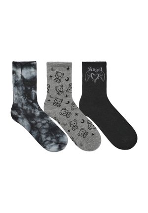 Tre paia di calzini: uno in tie-dye nero e grigio, uno grigio con motivi di orsetto e luna, e uno nero con la scritta "Angel" e design di ali.