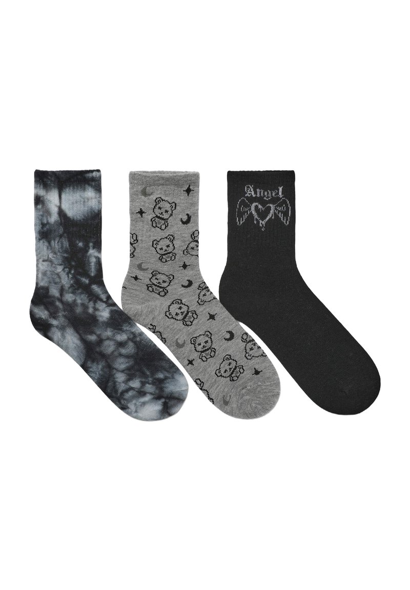 Tre paia di calzini: uno in tie-dye nero e grigio, uno grigio con motivi di orsetto e luna, e uno nero con la scritta "Angel" e design di ali.