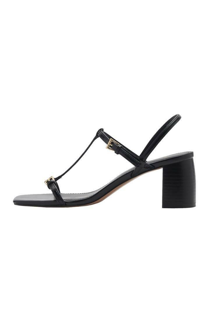 Sandal con tacco nero con design a T-strap, cinturini testurizzati e tacco a blocco. Presenta dettagli in metallo dorato e una suola liscia.